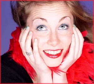 Woman making New Year wishes: Woman in red feather boa looking up into the air.